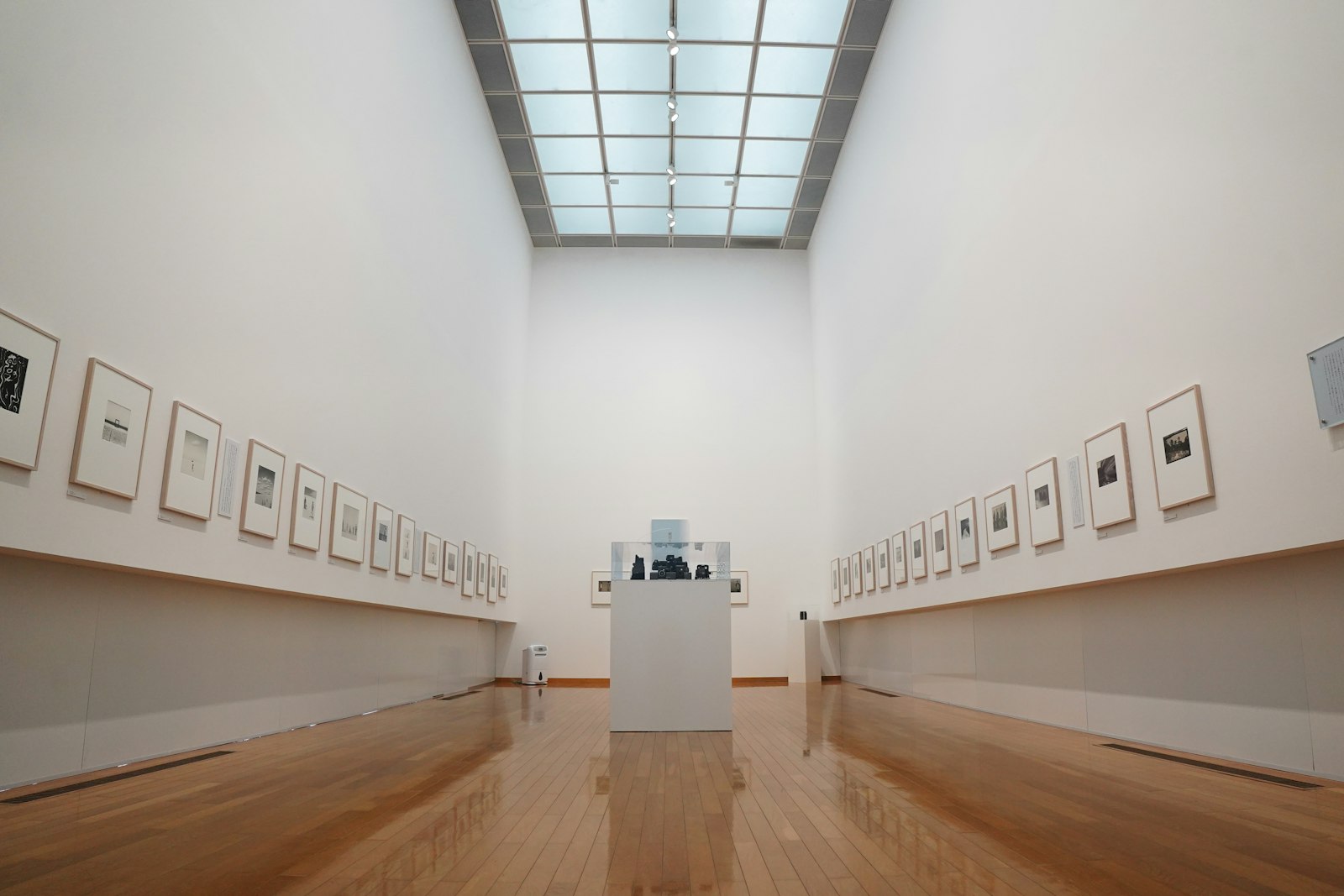 A minimalist white gallery hung with framed works